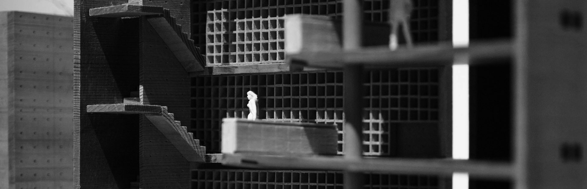 A sectioned architectural model, floor above floor, a single figure standing on one of them